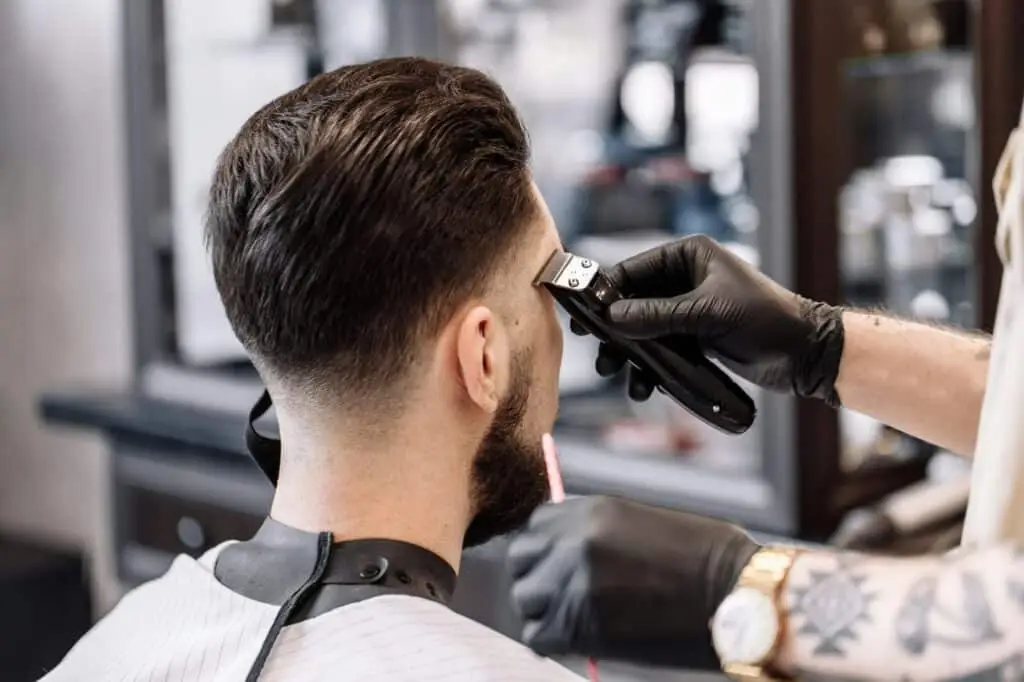 Classic haircut in a barbershop. Curve hair styling and hair health care in a barbershop.